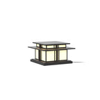 Lit against a white backdrop, this Clérachic pillar light glows through its frosted glass panels, cable trailing from the base.
