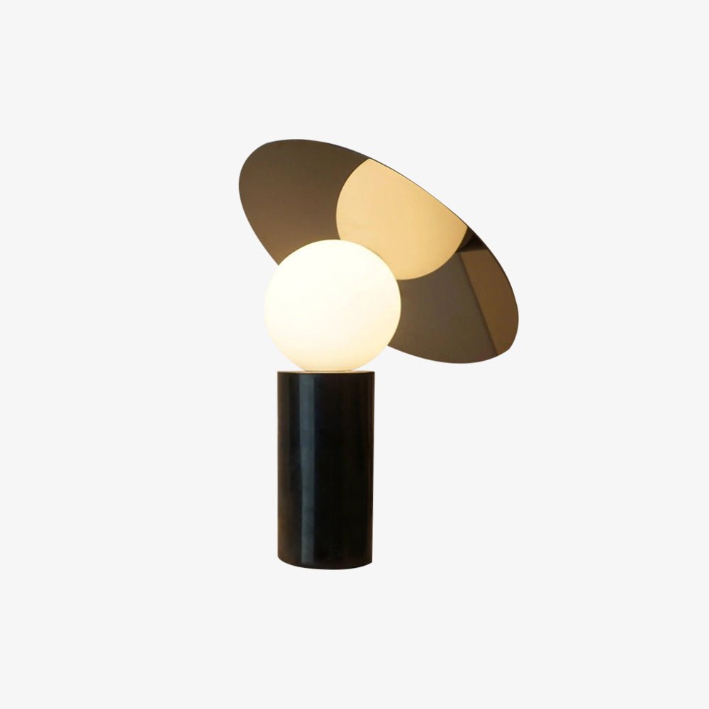 Clérachic tilting disc table lamp on a plain white background, its frosted glass globe unlit beneath the gold-toned panel.