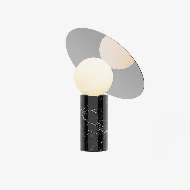 Clérachic disc lamp on a plain white background, its black marble base showing pale veining beneath the unlit mirrored disc.