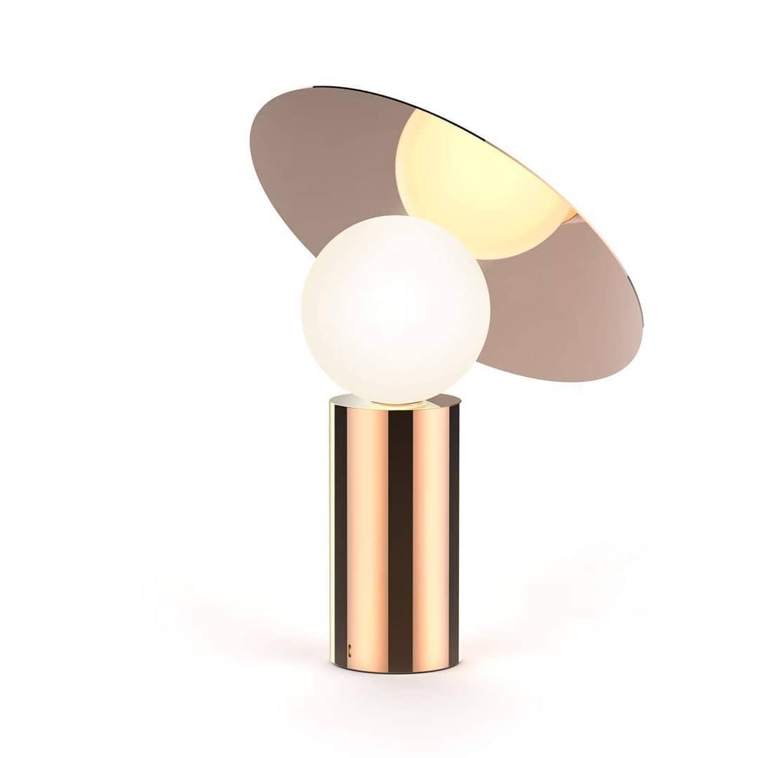 Clérachic disc lamp on a plain white background, its cylindrical copper-toned base topped by a bronze-mirrored tilted panel.