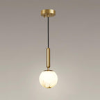 The full pendant with its round brass ceiling plate, black cord and lit alabaster globe.