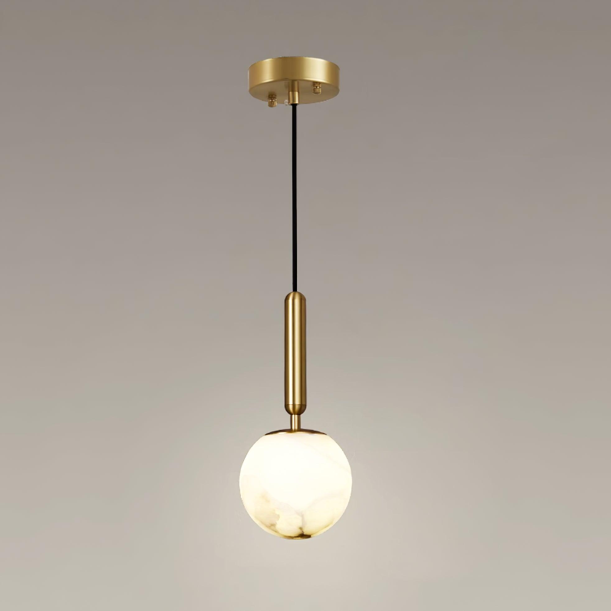 The full pendant with its round brass ceiling plate, black cord and lit alabaster globe.