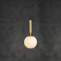 The same pendant on dark grey, its alabaster sphere glowing softly around the brass fitting.