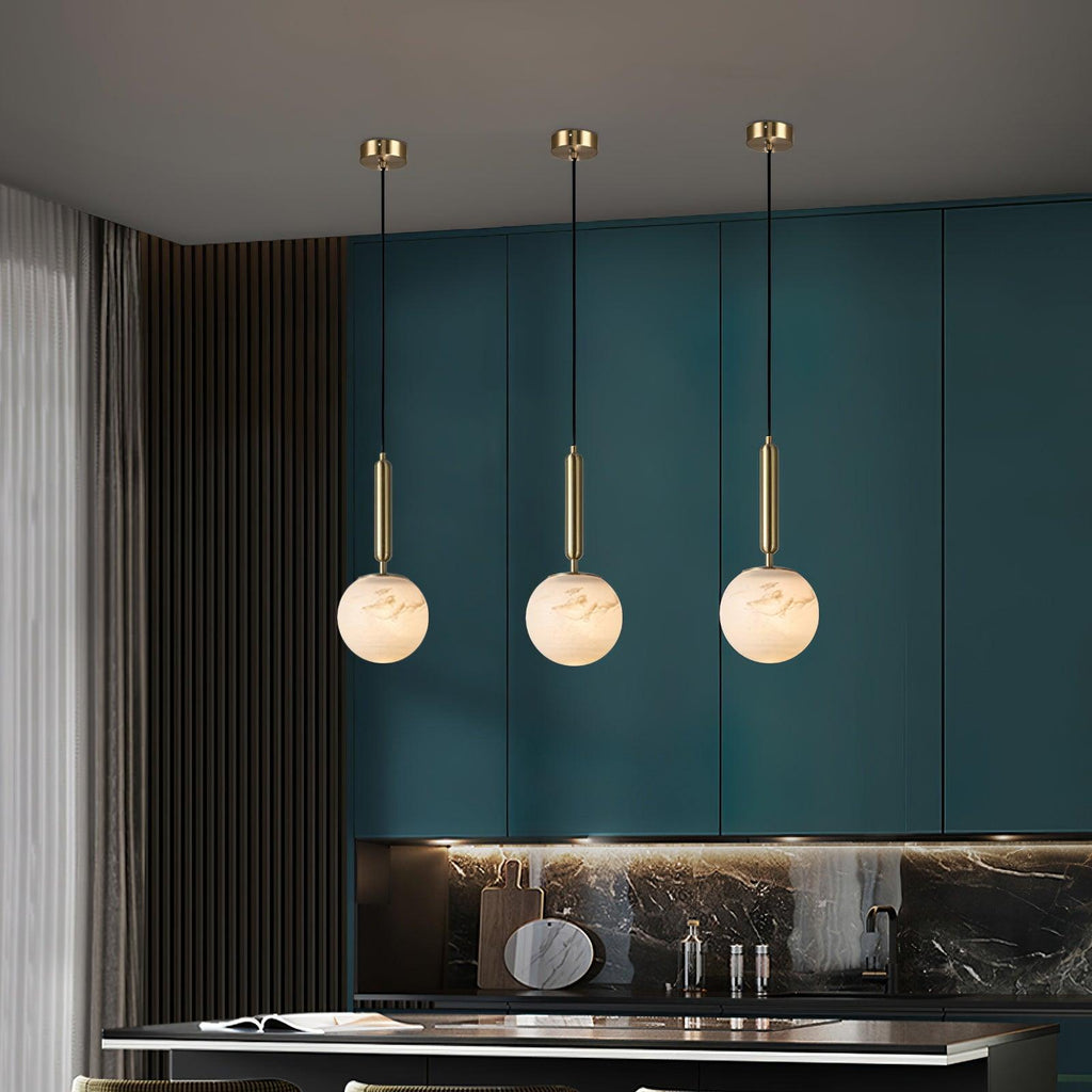 The pendant on white with its brass stem, alabaster globe unlit and softly veined.