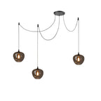 Wide dome smoke gray glass pendant glowing over a counter