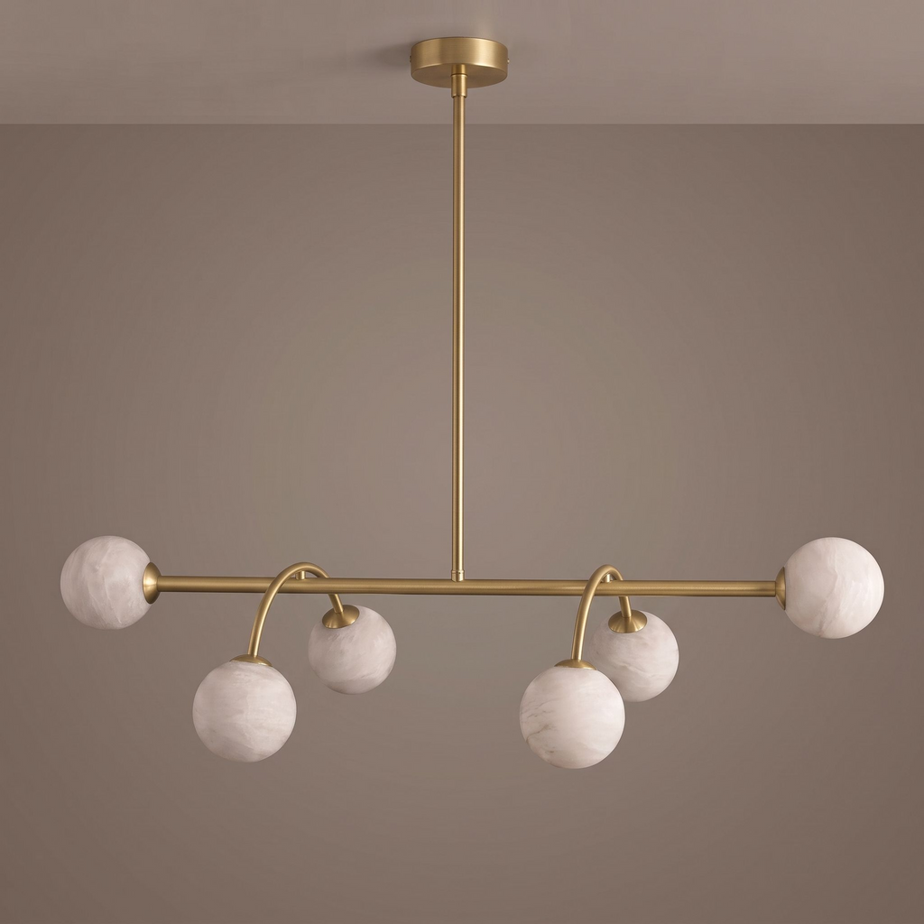 Studio shot of this Clérachic chandelier in brushed brass, seen face-on with its alabaster balls staggered below.