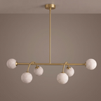 Studio shot of this Clérachic chandelier in brushed brass, seen face-on with its alabaster balls staggered below.