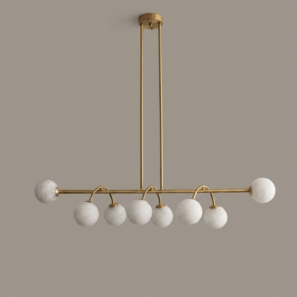 Front view of this Clérachic chandelier in brushed brass on a plain taupe backdrop, its balls hanging below the bar.