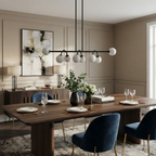 This matte-black Clérachic chandelier glows over a dining table with navy velvet chairs and an abstract print.