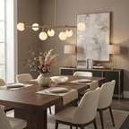 This brushed-brass Clérachic chandelier glows over a dining table styled with dried pampas and florals.