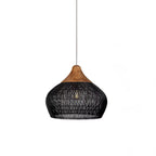 Black woven rattan pendant light shown lit in a calm room
