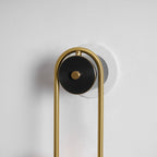 Curved brass wall light with two glowing white glass shades