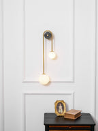 Curved brass wall light mounted as a sculptural feature