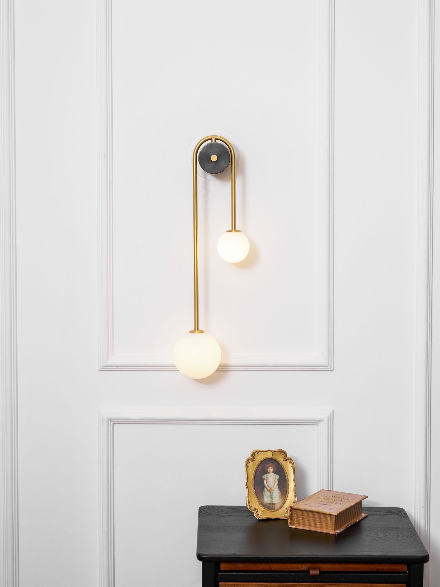 Curved brass wall light mounted as a sculptural feature