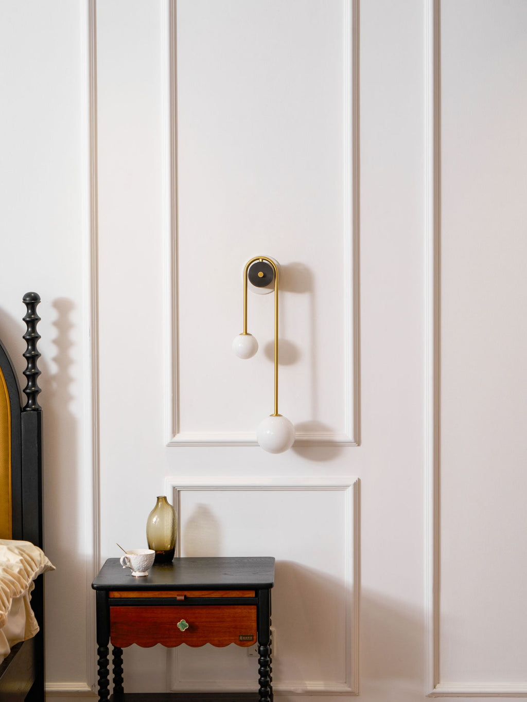 Brass arc wall light with two white shades viewed straight on
