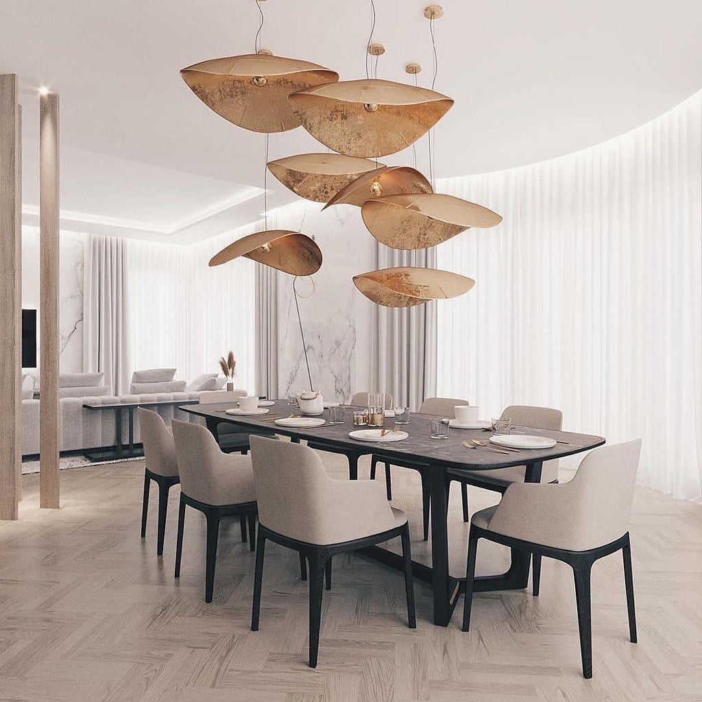 This Clérachic pendant cluster hangs above a set dining table framed by white curtains and columns.