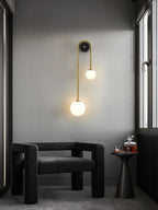 Curved brass wall light shown unlit with two white shades