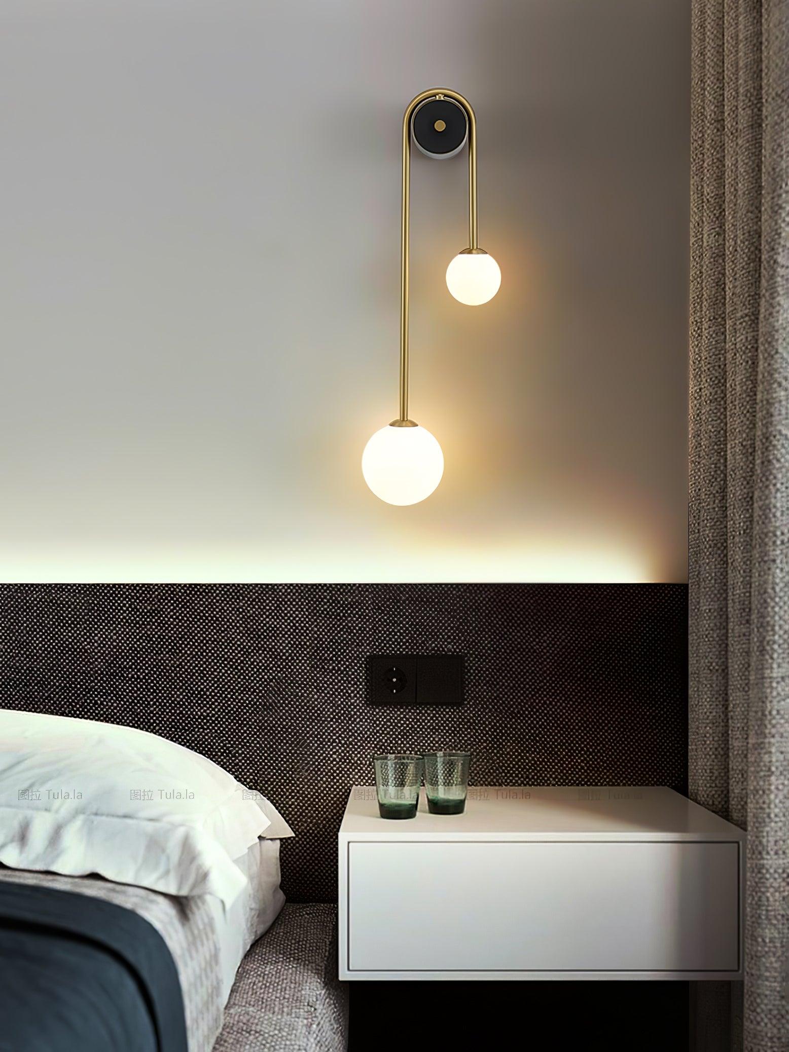 Brass arc wall light highlighting the offset shade arrangement