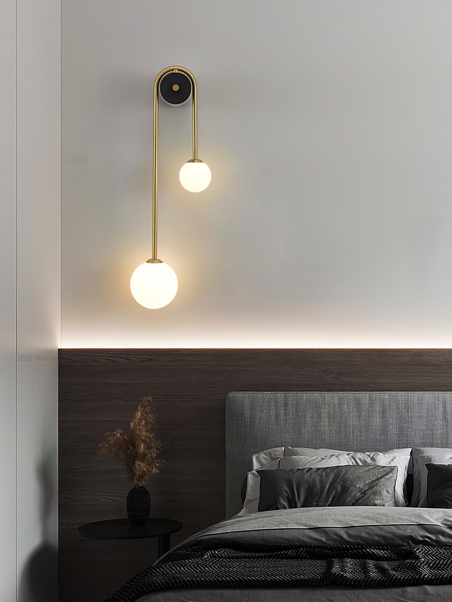 White glass shade detail on a curved brass wall light