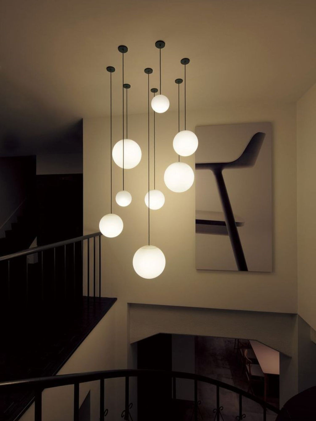 White opal glass globe pendant floating on a minimal brass rod