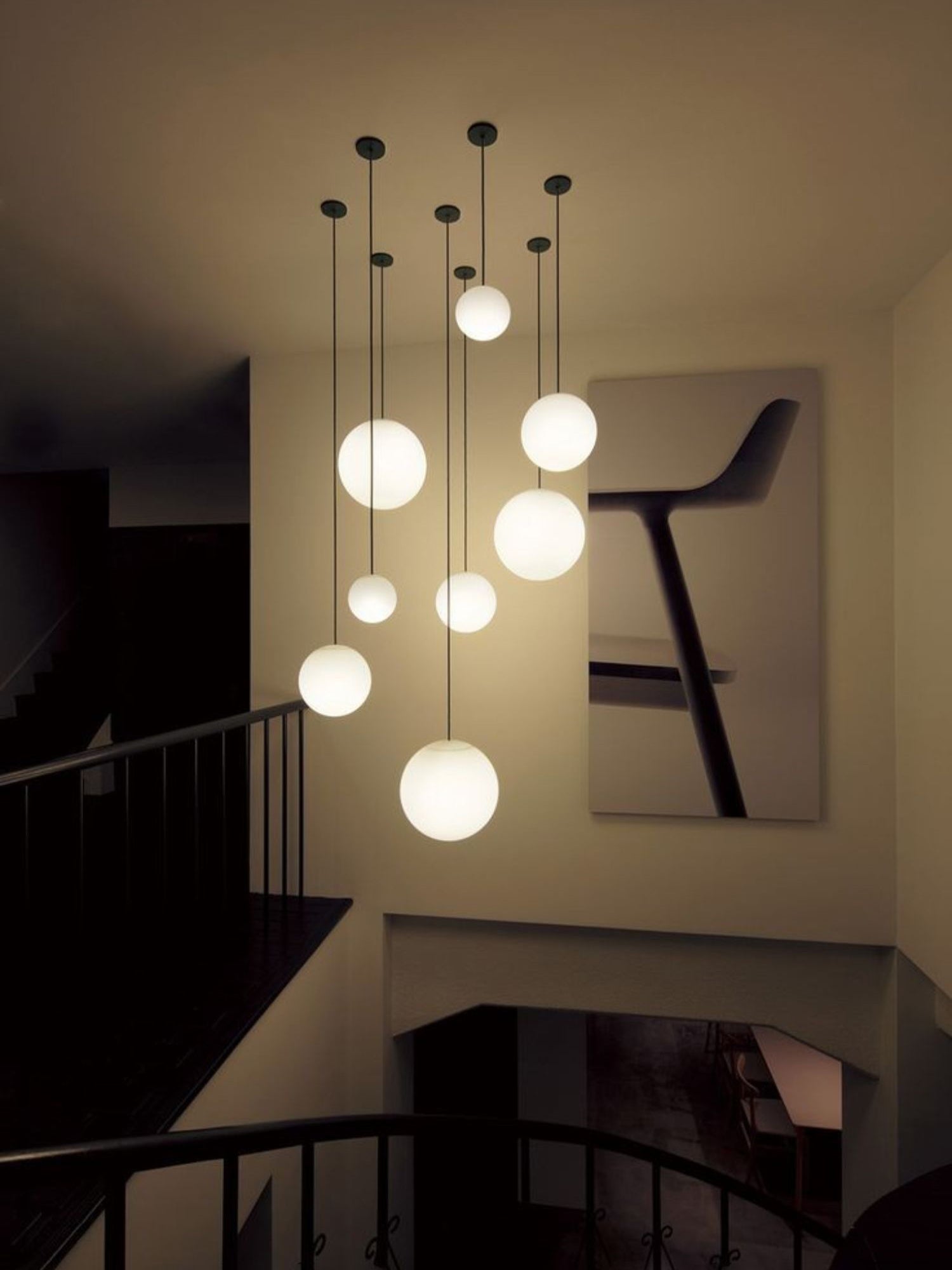 White opal glass globe pendant floating on a minimal brass rod