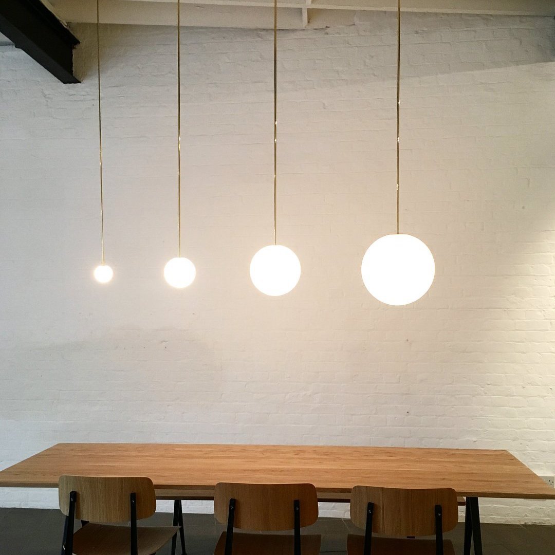 Brass rod globe pendant with white opal glass shade