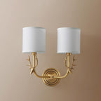 Brass deer head sconce with two white linen shades in a room