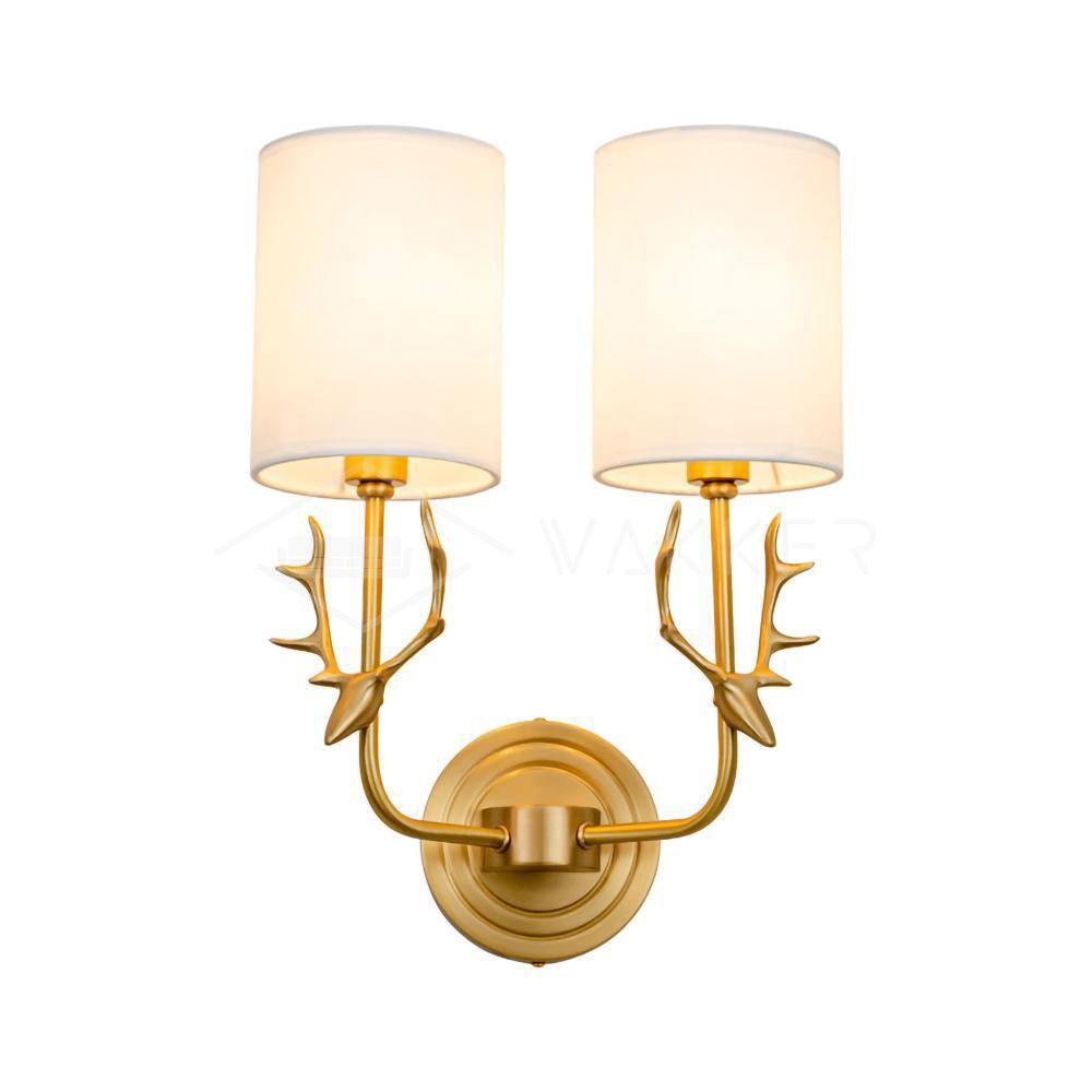 Sculptural brass antler wall light holding twin linen lampshades