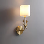 Brass antler wall light with warm linen-diffused glow on a wall