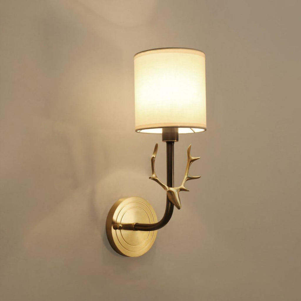 Brass deer head wall light shown with circular brass back panel
