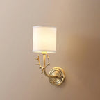 Brass deer head sconce on a wall with soft linen-diffused light