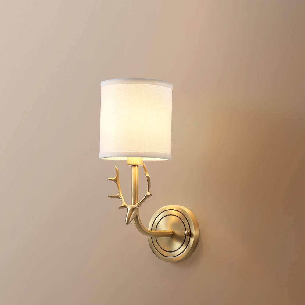Brass deer head sconce on a wall with soft linen-diffused light