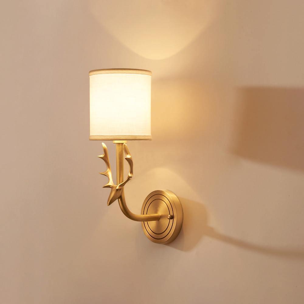 Sculptural brass antlered wall light holding two linen shades