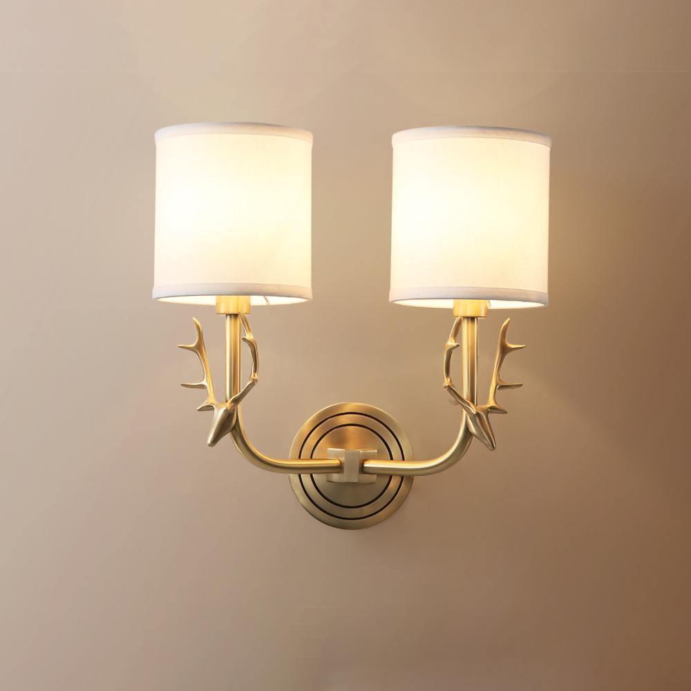 Brass deer head wall light shown close up with linen shade detail