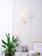 Sculptural brass deer head light with white linen shades on a wall