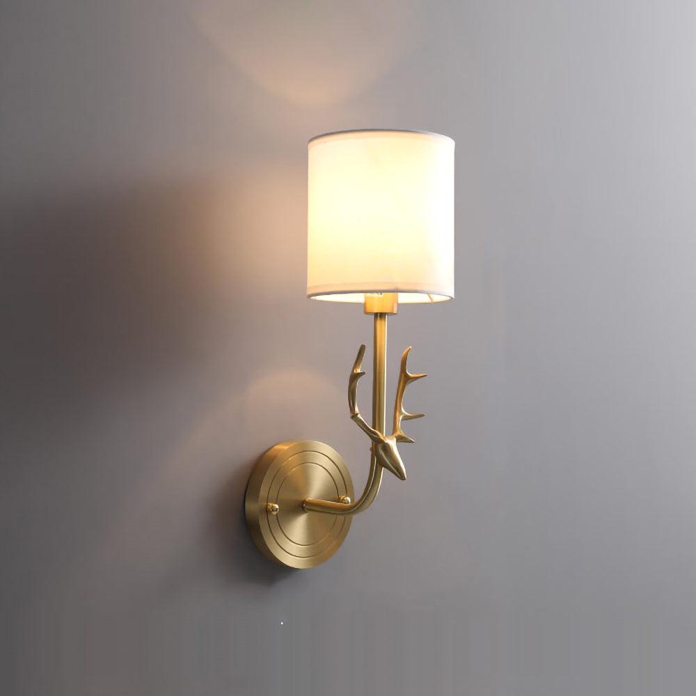 Brass deer head wall light shown against a neutral interior wall