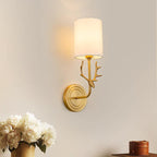 Brass antlered wall light with two warm linen shades lit