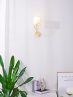 Brass deer head wall light with twin linen lampshades lit warmly