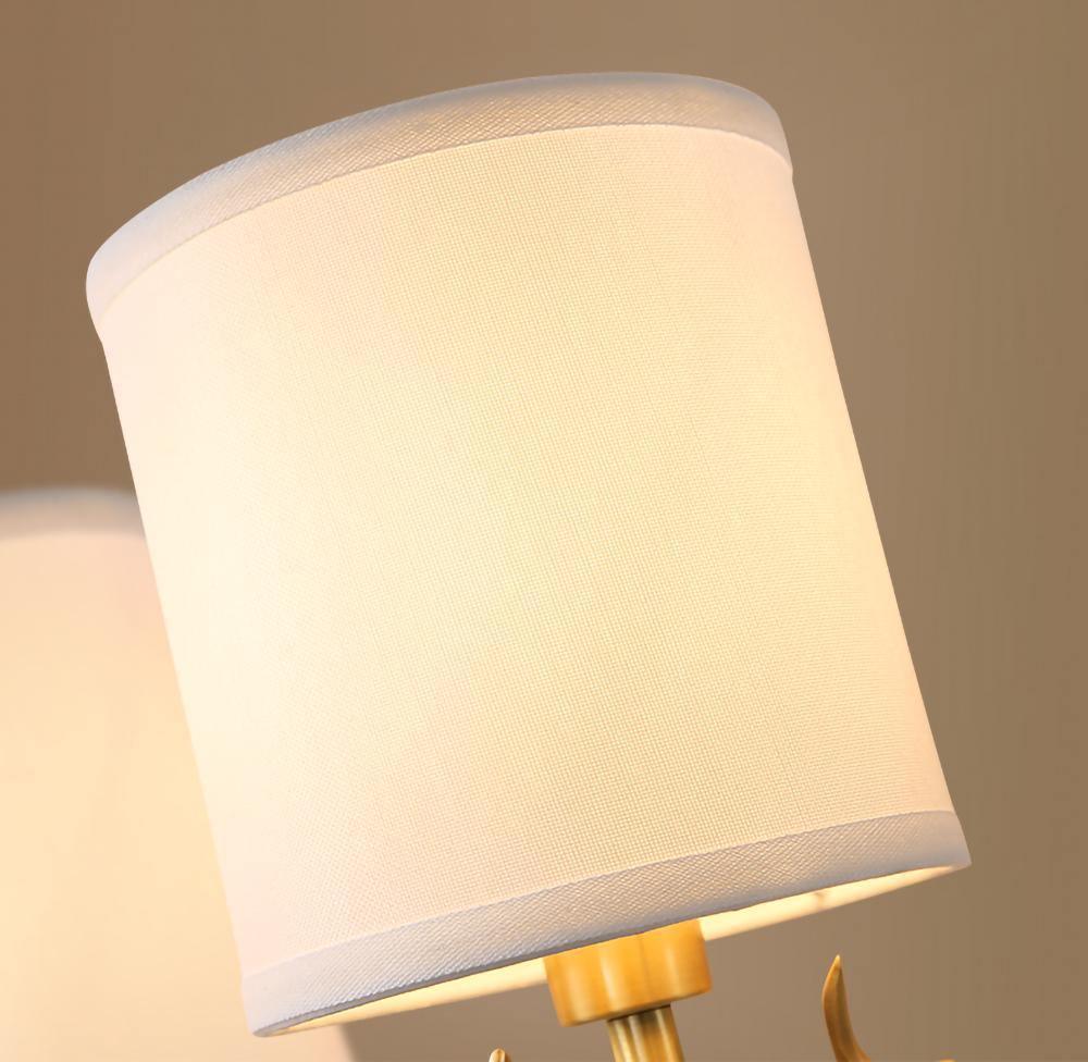 Brass deer head sconce glowing softly with white linen diffusers