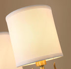 Brass deer head sconce glowing softly with white linen diffusers