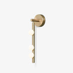 Brass glass tube wall lamp with white blown glass orbs lit warmly