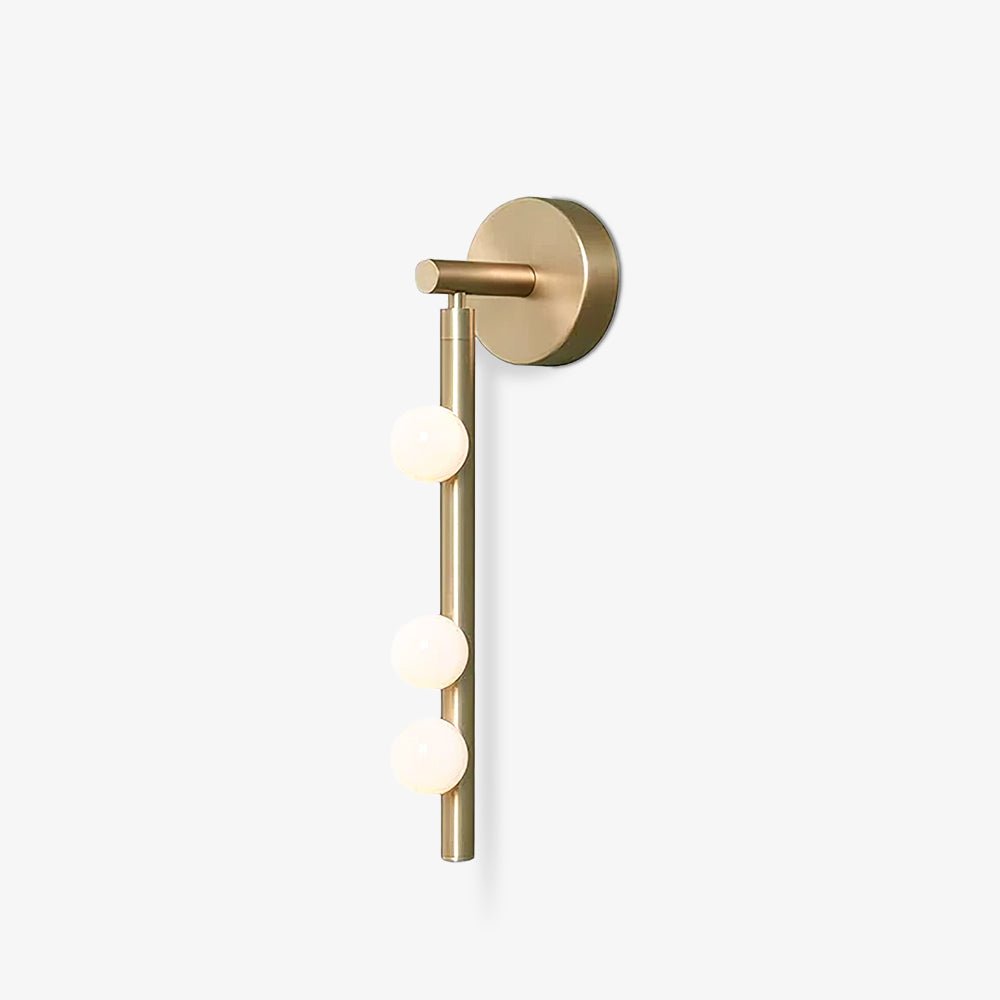Brass glass tube wall lamp with white blown glass orbs lit warmly