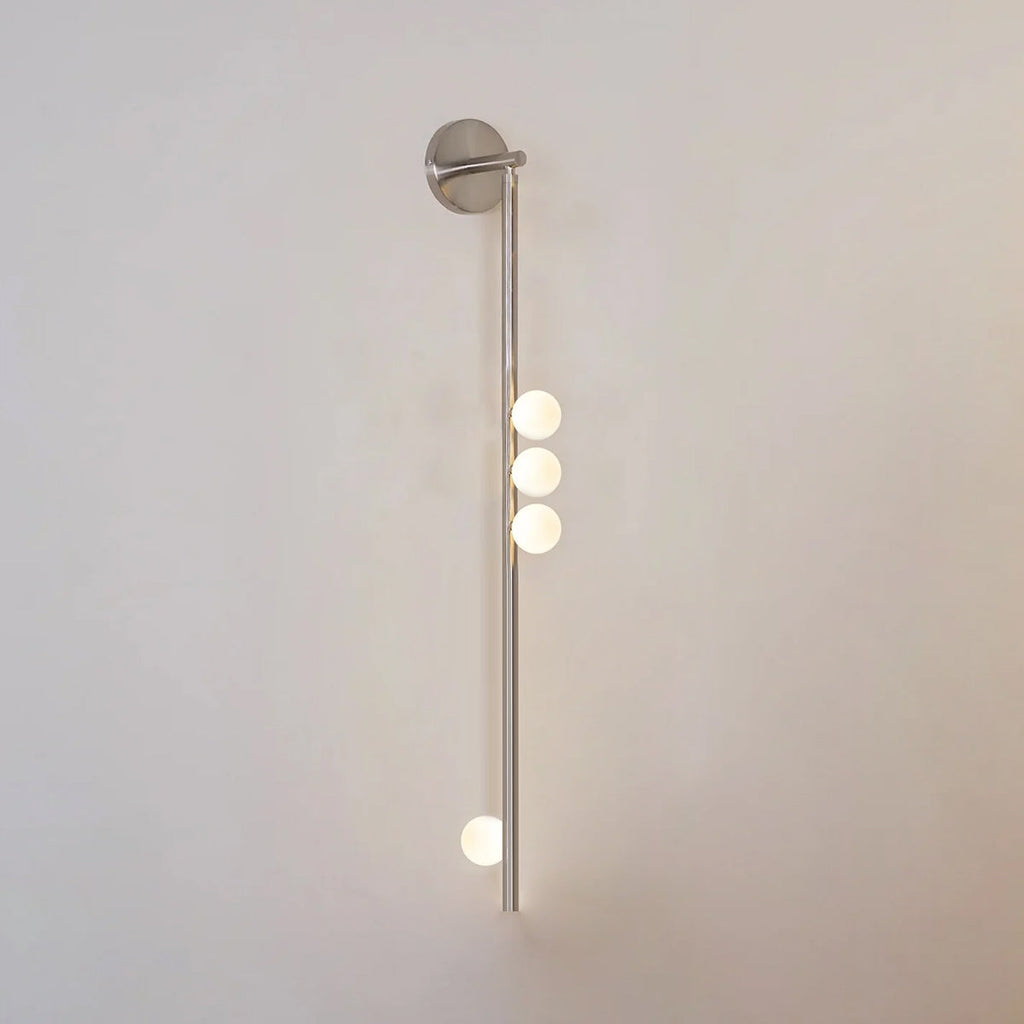 Glass tube wall lamp in brass with warm glowing globe shades