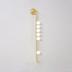 Brass glass tube wall lamp glowing softly in an intimate setting