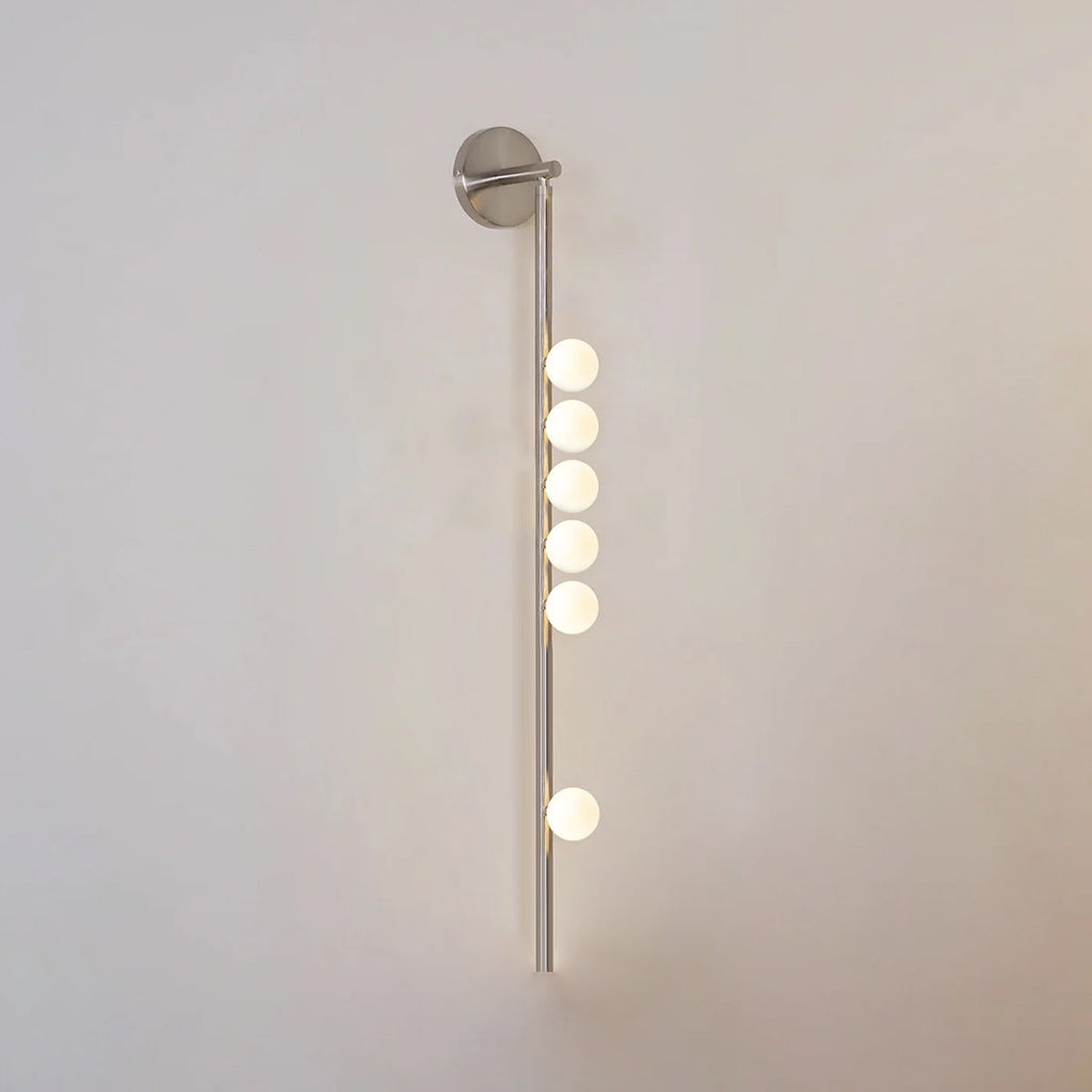 Glass tube wall lamp in brass with a horizontal row of orbs