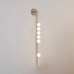 Glass tube wall lamp in brass with a horizontal row of orbs