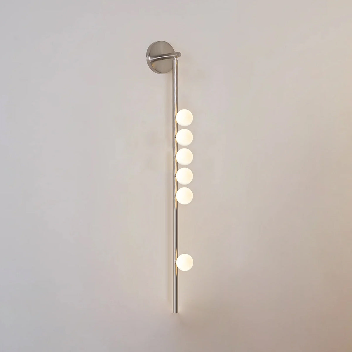 Glass tube wall lamp in brass with a horizontal row of orbs