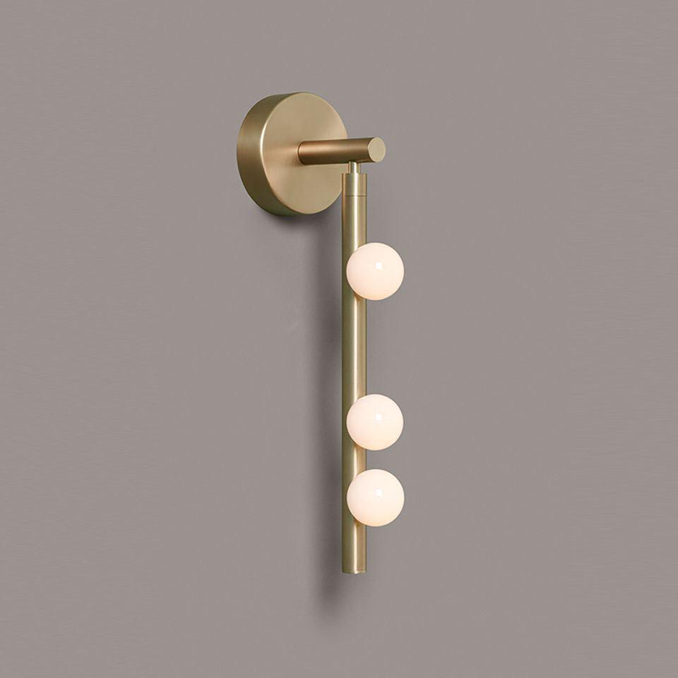 Brass glass tube wall lamp with hand-blown globes glowing warmly