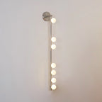Nickel glass tube wall lamp with a row of softly lit globes