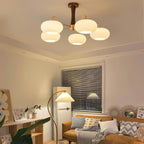 Persimmon chandelier with brass arms glowing in a bedroom